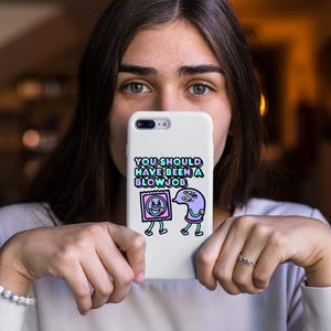 May include: White phone case with the text "YOU SHOULD HAVE BEEN A BLOWJOB" in a colorful font. The case features cartoon illustrations of a condom and a sperm cell with legs.