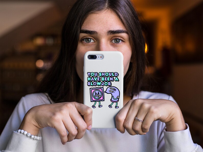 May include: White phone case with the text "YOU SHOULD HAVE BEEN A BLOWJOB" in a colorful font. The case features cartoon illustrations of a condom and a sperm cell with legs.