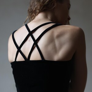 May include: A black velvet dress with criss-cross straps at the back.