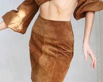 Könnte beinhalten: Ein brauner Wildleder-Minirock mit hoher Taille und gerader Silhouette.