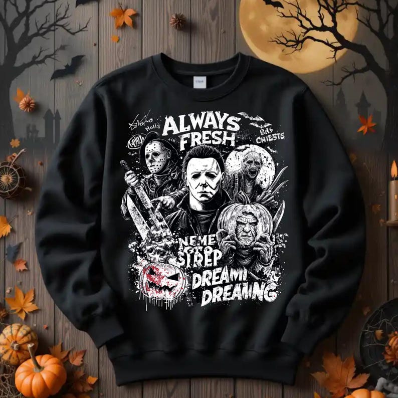 May include: Black sweatshirt featuring a graphic design with horror movie characters and the text "ALWAYS FRESH". The design includes images of Michael Myers, Jason Voorhees, and other horror figures, with the words "Neme Strep Dreami Dreaming".