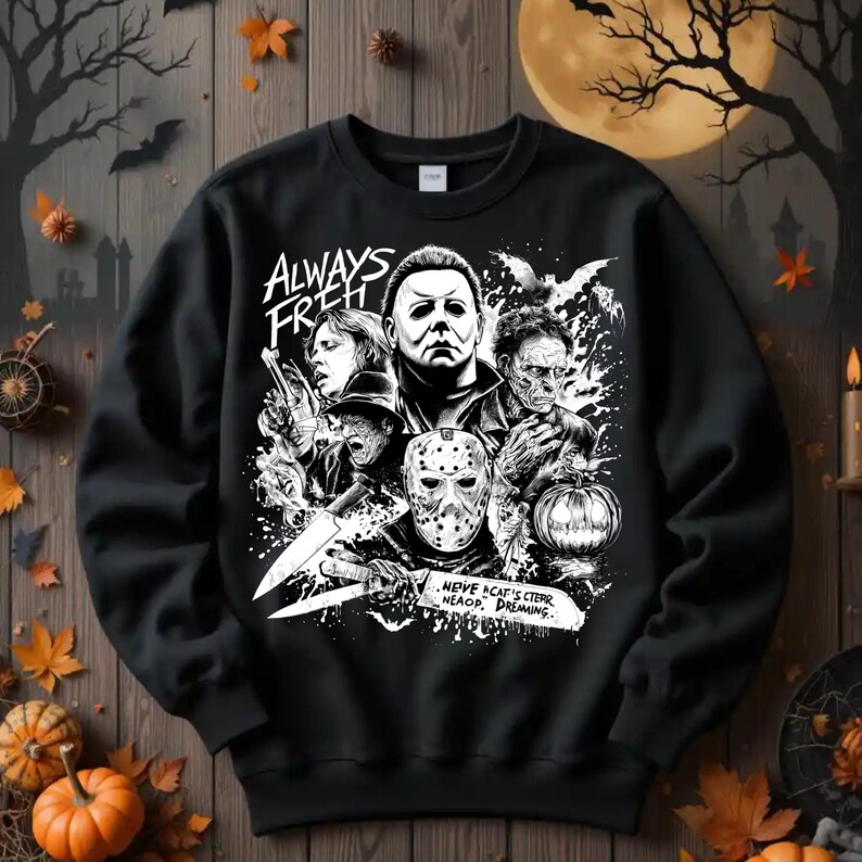 May include: Black sweatshirt featuring a Halloween-themed graphic with the text "ALWAYS FRESH." The design includes images of horror movie characters, a pumpkin, and bats. The phrase "...NEVE ACAP'S CTEPR NEAOP, DREAMING..." is also visible.
