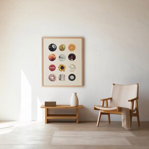 May include: A bright room with a framed artwork displaying circular images. A wooden bench holds a white vase and books. A wooden chair with a cream-coloured throw is positioned nearby. The room has a minimalist aesthetic with wooden beams.