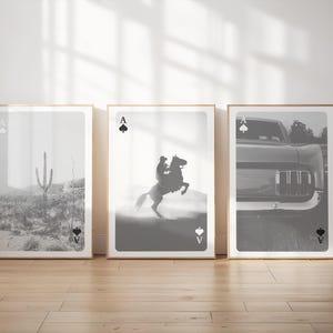 Op de afbeelding: Drie ingelijste zwart-wit prints. De prints tonen een woestijnlandschap met een cactus, een cowboy op een steigerend paard en de voorkant van een klassieke auto. Elke print heeft een speelkaartenontwerp.