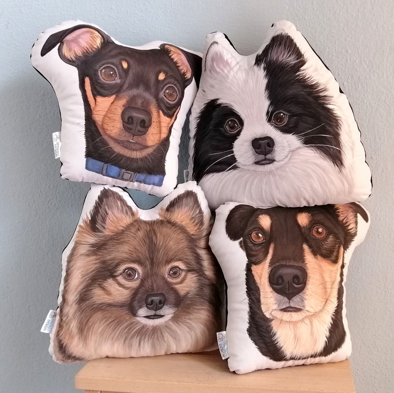 May include: Four white pillow covers with black trim, each featuring a different dog breed. The pillows feature a black and tan miniature pinscher, a black and white pomeranian, a brown and white pomeranian, and a black and tan terrier mix.
