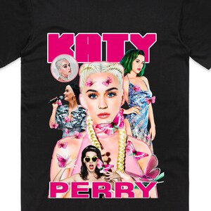 May include: Black t-shirt with a collage of Katy Perry images and pink butterflies. The name "KATY" is in pink block letters above the images, and "PERRY" is printed below.