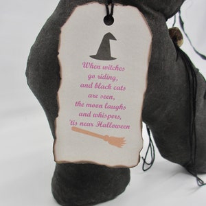 May include: A black fabric witch's boot with a white tag that reads "When witches go riding, and black cats are seen, the moon laughs and whispers, 'tis near Halloween".
