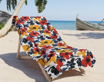 Könnte beinhalten: Ein Strandstuhl mit einem bunten Blumenmuster in Rot-, Gelb- und Blautönen. Der Stuhl ist aus Holz und hat einen weißen Stoffbezug.