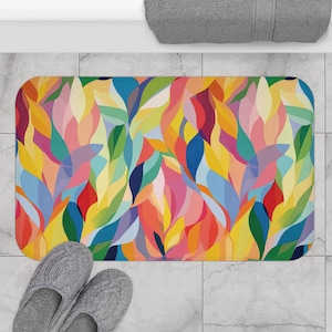 Könnte beinhalten: Abstrakter Badeteppich mit einem farbenfrohen Design aus überlappenden Blättern in den Farben Gelb, Orange, Rosa, Blau, Grün und Rot.
