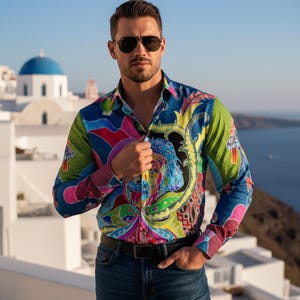 Puede incluir: Camisa de manga larga con un estampado vibrante y colorido. La camisa presenta una mezcla de tonos azules, verdes, rosas y amarillos con un diseño intrincado. La camisa se combina con vaqueros azules y un cinturón marrón.