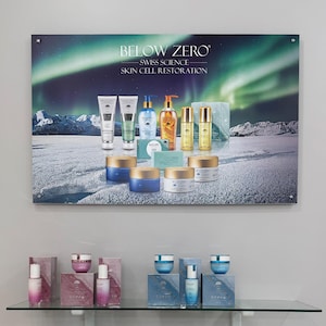 K&ouml;nnte beinhalten: Eine Pr&auml;sentation von Below Zero Swiss Science Skin Cell Restoration Produkten. Die Produkte sind auf einer schneebedeckten Landschaft mit einem gr&uuml;n-blauen Nordlicht im Hintergrund angeordnet. Die Produkte umfassen eine Vielzahl von Cremes, Seren und Lotionen.