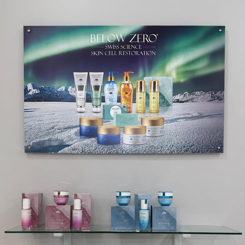 K&ouml;nnte beinhalten: Eine Pr&auml;sentation von Below Zero Swiss Science Skin Cell Restoration Produkten. Die Produkte sind auf einer schneebedeckten Landschaft mit einem gr&uuml;n-blauen Nordlicht im Hintergrund angeordnet. Die Produkte umfassen eine Vielzahl von Cremes, Seren und Lotionen.