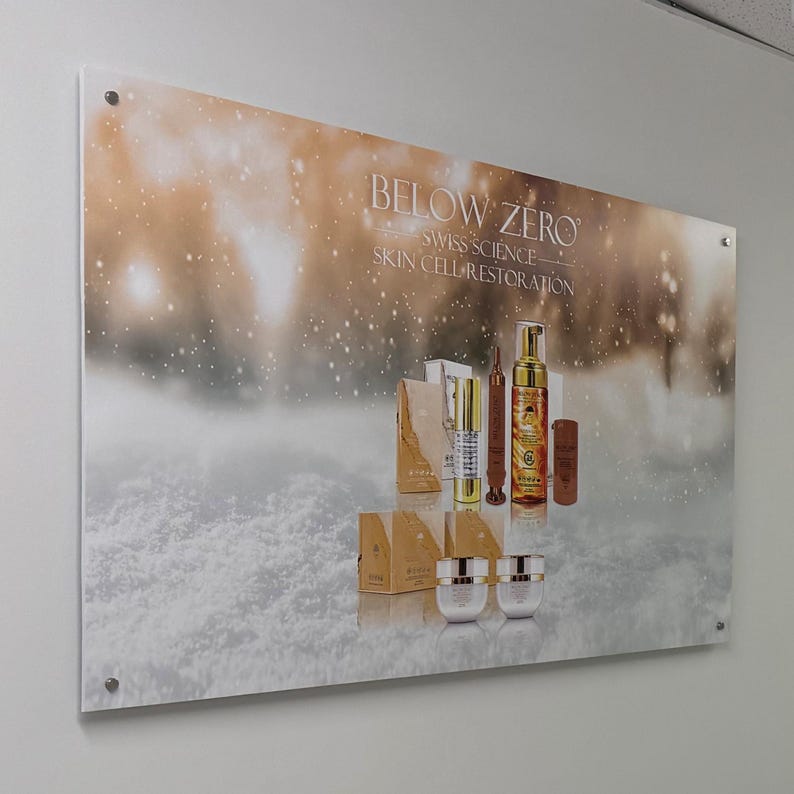 K&ouml;nnte beinhalten: Eine Produktpr&auml;sentation einer Hautpflegelinie namens "Below Zero Swiss Science Skin Cell Restoration". Die Produkte werden vor einem schneebedeckten Hintergrund mit einem gold-wei&szlig;en Farbschema pr&auml;sentiert. Die Produkte umfassen eine Flasche Gesichtswaschmittel, ein Serum, eine Creme und eine Tasche.