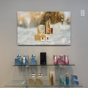 K&ouml;nnte beinhalten: Eine Pr&auml;sentation von Hautpflegeprodukten mit einem schneebedeckten Hintergrund, auf dem der Text "BELOW ZERO - SWISS SCIENCE - SKIN CELL RESTORATION" steht. Die Produkte sind in goldenen und wei&szlig;en Verpackungen und umfassen Cremes, Seren und eine Flasche Gesichtswaschmittel.