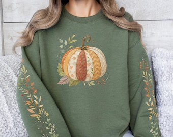 Könnte beinhalten: Olivgrünes Sweatshirt mit einem Aquarell-Kürbis-Design in Orange, Braun und Creme. Die Ärmel haben florale und blattartige Akzente in Herbstfarben. Ein bequemer, lässiger Stil.