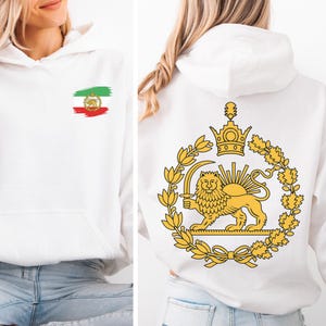 May include: White hoodie with a front pocket and a hood. The front features a small Iranian flag design. The back displays a gold emblem of a lion holding a sword, surrounded by a wreath and a crown. The hoodie is made of a soft material.