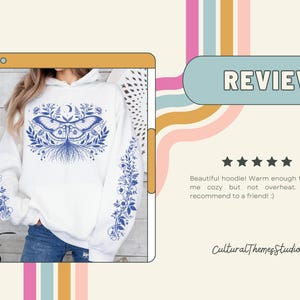 May include: White hoodie with a blue moth and floral design on the front and sleeves. The word "REVIEW" is in a blue oval. The text "Cultural Themesstudio" is at the bottom.