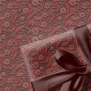 May include: A gift box wrapped in paper with a floral pattern in shades of red and brown. The paper has a raised, textured design. A dark brown satin ribbon is tied in a bow on top of the box, adding a touch of elegance.