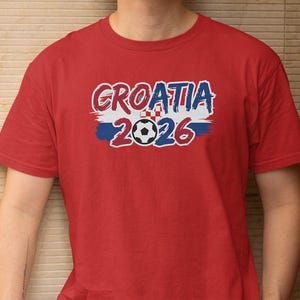 A red t-shirt with the text "GROATIA 2026" printed on it, along with a soccer ball graphic.