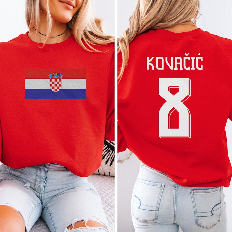 A woman wearing a red shirt with the Croatia national flag and the number 8 on the back, as well as a sports jersey with the name 'KOVACIÓG' and the number '8' on the back.