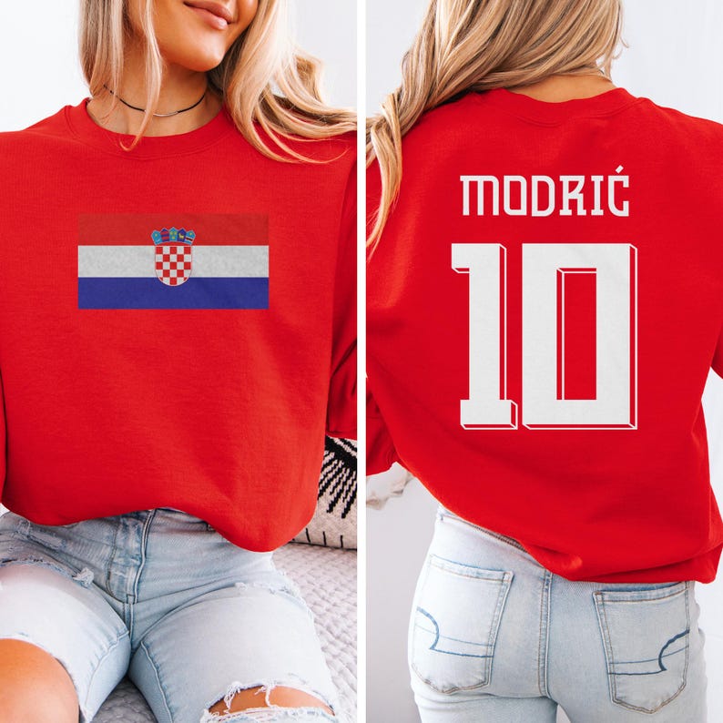 A woman wearing a red shirt with the Croatia national flag and the number 10 on it, as well as a jersey with the name "Modric" and the number 10 on it.