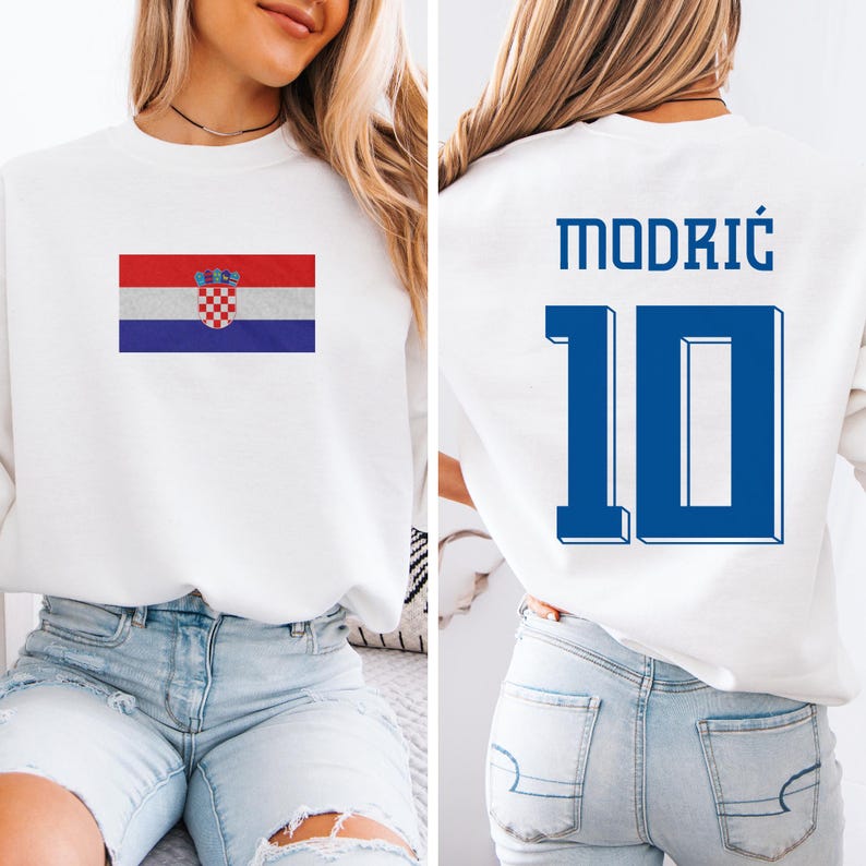 A woman wearing a white sweatshirt with a Croatia flag and the number 10 on the back, as well as a jersey with the name "Modric" and the number 10.