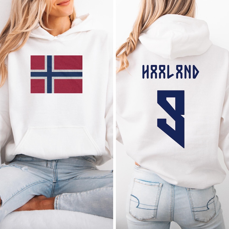 A woman wearing a white hoodie with the flag of Norway and the number "HRLAND" printed on the back.