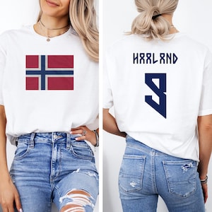 A woman wearing a white t-shirt with the flag of Norway and the number 9 on the back, along with blue jeans.