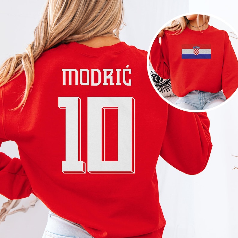 A woman wearing a red sports jersey with the number 10 and the name "Modric" printed on it.