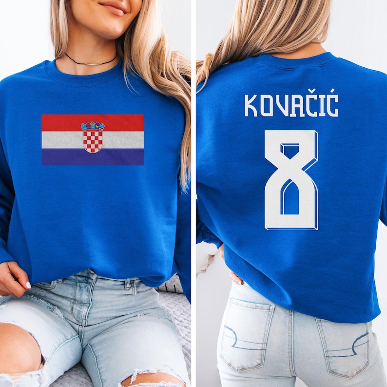 A woman wearing a blue sweatshirt with the Croatia national flag and the number 8 printed on it.