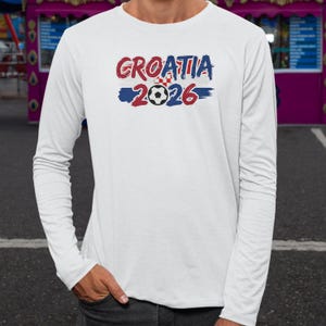 A person wearing a white long-sleeved shirt with the text "GROATIA 2006" printed on it.