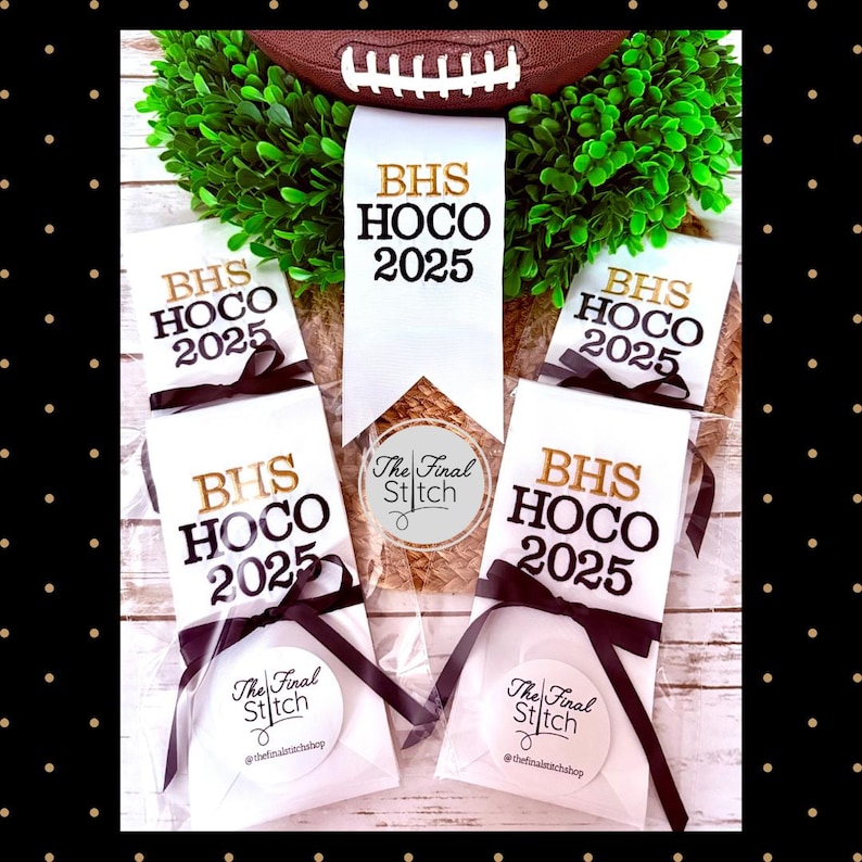 May include: Five white fabric ribbons featuring the text BHS HOCO 2025 in gold and black lettering. Each ribbon is tied with a black satin bow and packaged in clear plastic. A circular sticker with the text The Final Stitch is attached.