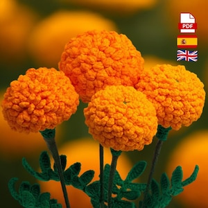 Puede incluir: Primer plano de cuatro flores de caléndula naranja tejidas a ganchillo con tallos y hojas verdes. Las flores tienen un aspecto texturizado, similar a un pompón. El fondo es un degradado borroso de naranja y verde.