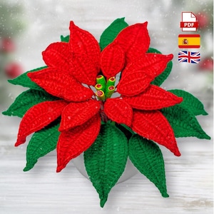 Puede incluir: Una flor de pascua hecha a mano con pétalos rojos vibrantes y hojas verdes. La flor de ganchillo es una decoración festiva, perfecta para la temporada navideña. Un hermoso artículo artesanal detallado.
