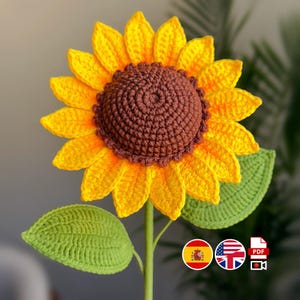 Puede incluir: Un girasol de ganchillo hecho a mano con pétalos amarillos brillantes, un centro marrón y hojas verdes. El tallo es verde. El girasol es un artículo decorativo.