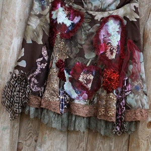 May include: A brown skirt with a floral print and layered lace trim. The skirt has a variety of embellishments, including sequins, beads, and fabric flowers.