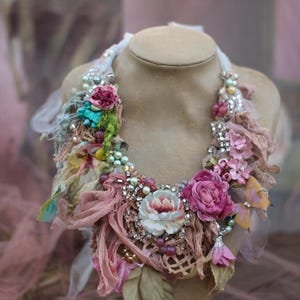 Collana assemblata e cucita a mano con passamanerie e lacci vintage, tessuti di recupero, cristalli e perline.