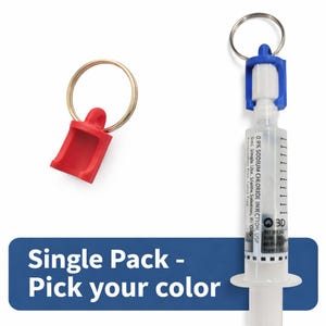 May include: A clear syringe with a blue and white cap attached to a keyring, and a red plastic keychain. The syringe has text that reads "0.9% SODIUM CHLORIDE INJECTION, USP". The text "Single Pack - Pick your color" is on a blue banner.
