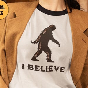 Unisex Cotton Ringer T-Shirt - I Believe in Bigfoot, Funny Sasquatch Tee, Great for Outdoor Lovers, Gift for Cryptid Fans, Casual Wear