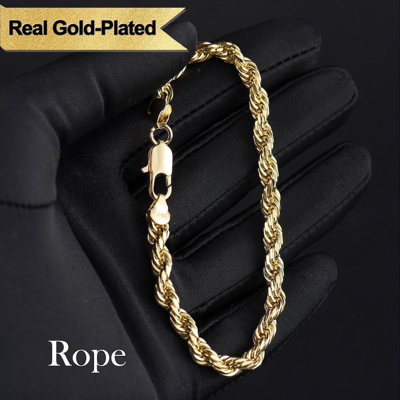 May include: A gold-plated rope bracelet with a lobster clasp, displayed on a black surface. The bracelet is made of twisted links, and the image includes the text "Real Gold-Plated" and "Rope".