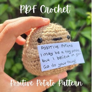 May include: A crocheted potato with black button eyes and a stitched mouth, held in a hand. A small white paper attached reads "POSITIVE POTATO I may be a tiny potato, but I believe in you. Go do your thing!" The text "PDF Crochet" and "Positive Potato Pattern" are also visible.