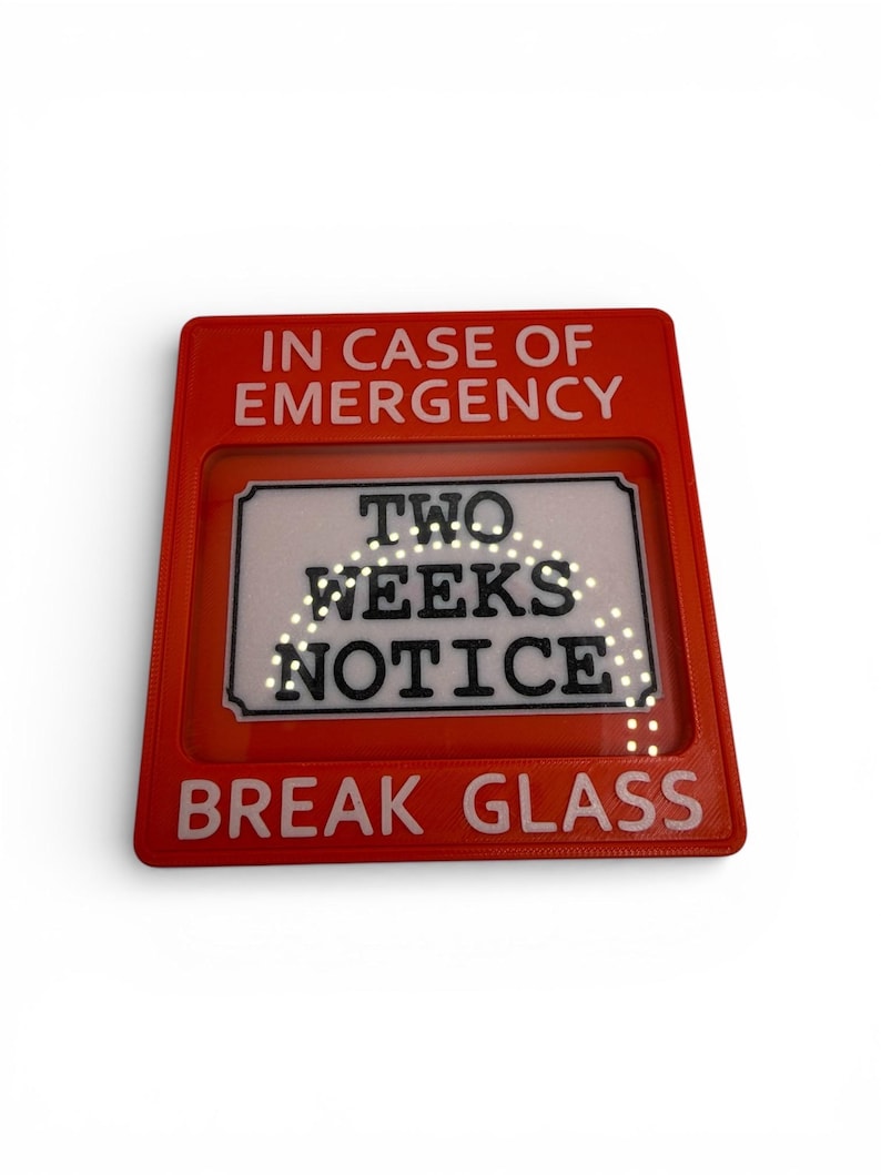 May include: A red rectangular sign with white text reading "IN CASE OF EMERGENCY" and "BREAK GLASS". The centre section displays "TWO WEEKS NOTICE". A humorous novelty item.