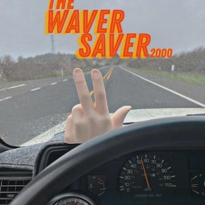 May include: A dashboard view from inside a vehicle showing a speedometer and tachometer with a light-colored hand gesture figurine mounted on the dash. The text THE WAVER SAVER 2000 is displayed in orange and yellow letters against a road background.