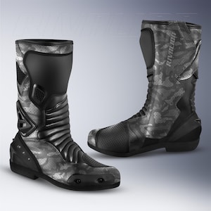 Puede incluir: Par de botas de moto negras y grises con estampado de camuflaje. Las botas tienen caña alta, paneles reforzados y la palabra "RIVALION" impresa en el lateral. Diseñadas para protección y rendimiento.