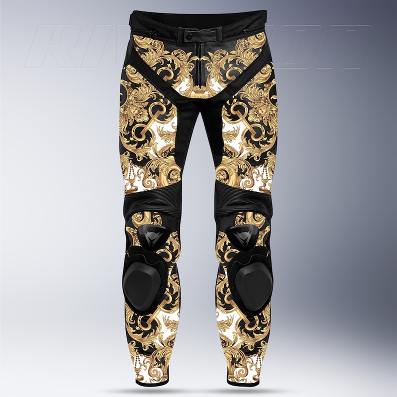 May include: Black and gold motorcycle pants with a baroque pattern. The pants feature a black leather belt, knee pads, and a white background with a gold floral design. The pants are designed for motorcycle riding.
