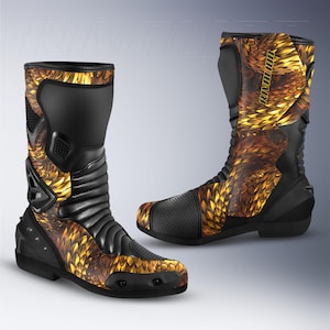 Könnte beinhalten: Paar schwarzer und goldener Motorradstiefel mit schuppenartigem Muster. Die Stiefel haben einen hohen Schaft, verstärkte Einsätze und das Wort "RIVALION" auf der Seite. Die Stiefel sind auf Schutz und Stil ausgelegt.