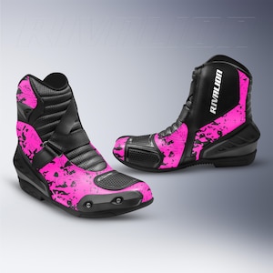 Könnte beinhalten: Paar schwarze und pinkfarbene Motorradstiefel. Die Stiefel haben ein hoch geschnittenes Design mit einem strukturierten schwarzen Lederobermaterial und einem pinkfarbenen Spritzmuster. Der Markenname "RIVALION" ist auf der Seite aufgedruckt.