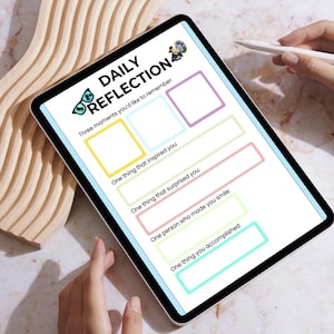 K&ouml;nnte beinhalten: Ein digitales Tablet mit einer Vorlage f&uuml;r "T&auml;gliche Reflexion". Die Vorlage enth&auml;lt Aufforderungen zum t&auml;glichen Journaling, wie z. B. "Drei Momente, an die Sie sich erinnern m&ouml;chten" und "Eine Sache, die Sie inspiriert hat". Das Tablet wird von einer Person gehalten.