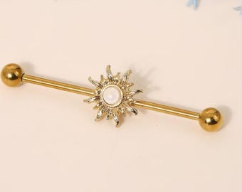 May include: Gold barbell with a sun design and a white pearl in the centre. The barbell is made of surgical steel and is suitable for body piercing.