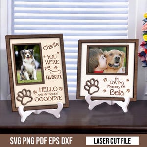 May include: Two wooden photo frames with white stands. One frame has a photo of a dog and the text "Charlie, You Were My Favorite, Hello and My Hardest Goodbye." The other frame has a photo of a child kissing a dog and the text "In Loving Memory Of Bella."